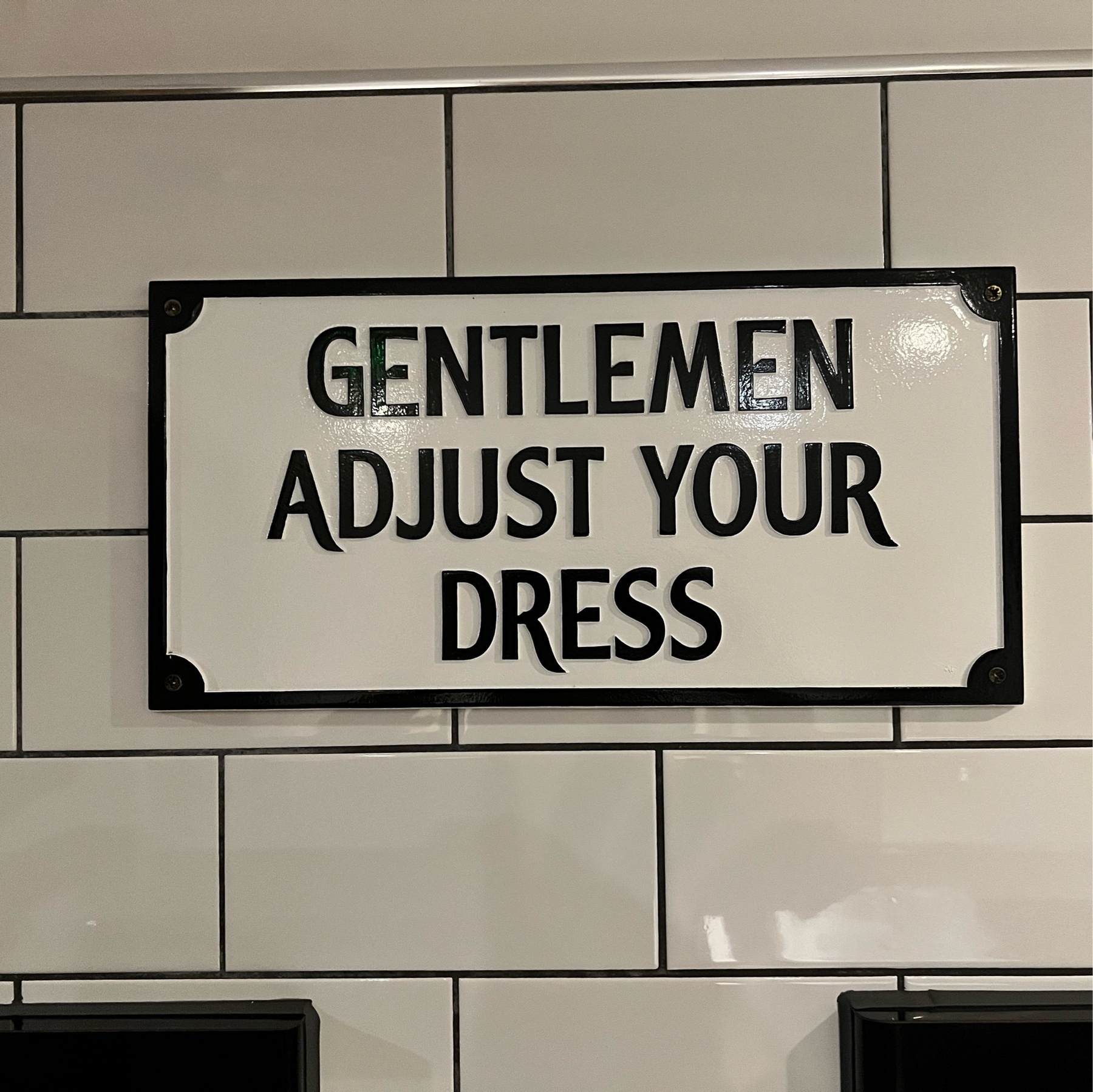 A sign in a pub toilet saying "Gentlemen adjust your dress". 