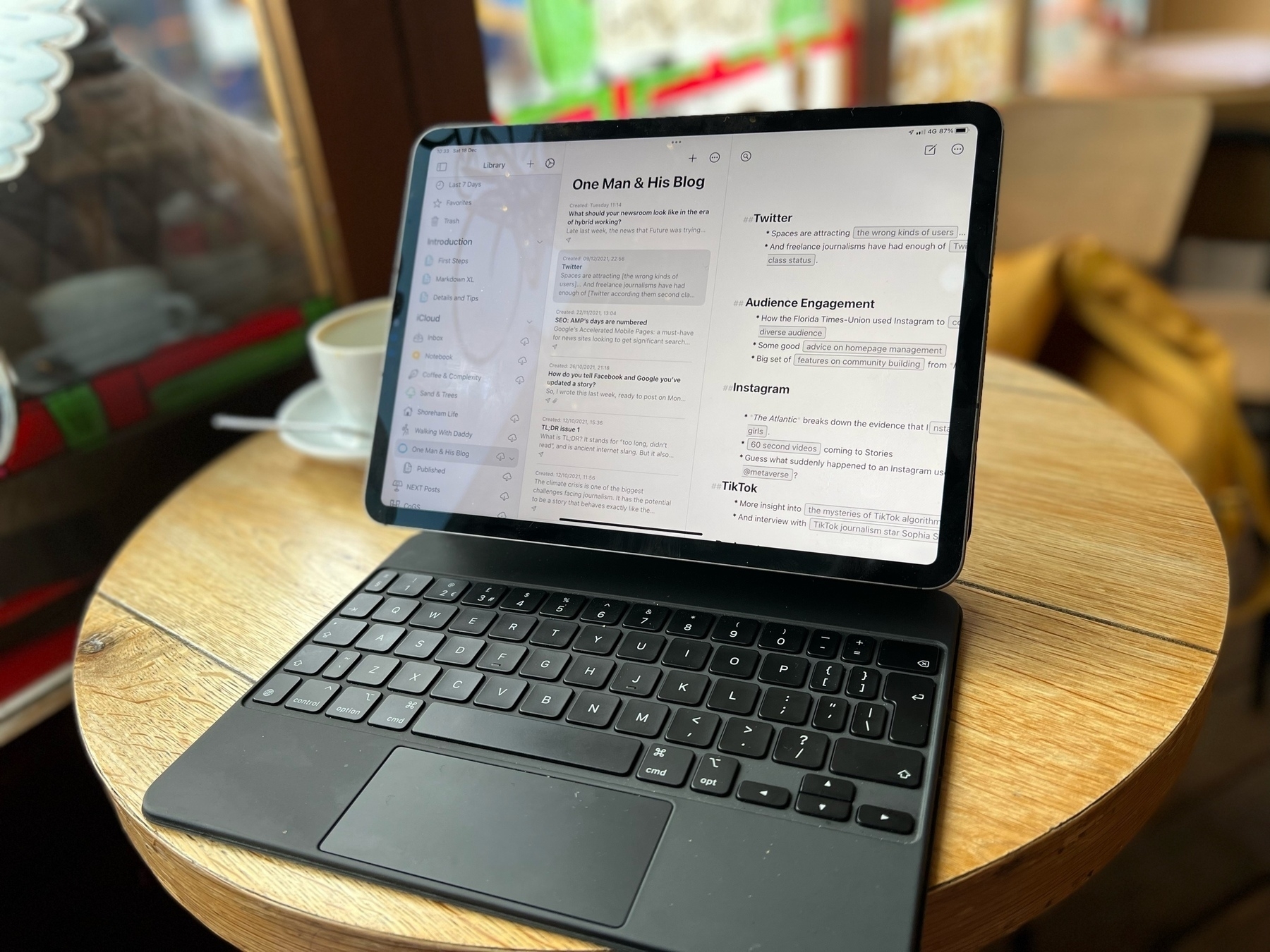 An iPad Pro with Magic Keyboard on a table in a coffee shop. 